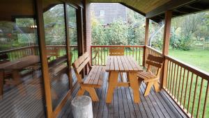 a porch with a wooden table and two benches at Ferienhaus Otto in Garding