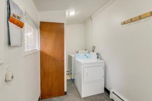 a laundry room with a washer and a wooden door at Anchorage Townhome 2 Mi to Dwtn! in Anchorage +16 photos