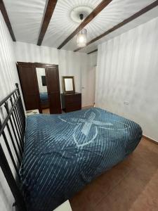 Un dormitorio con una cama con un edredón azul. en Casa pangea, en Ronda