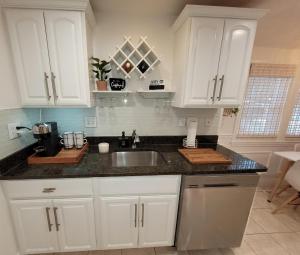 Una cocina con gabinetes blancos y un fregadero. en Cozy house, close to downtown Danvers, en Danvers 7 fotos más