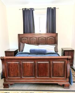 a wooden bed with a wooden frame in a bedroom at Hilltop Riverview Retreat in Clayton Bay