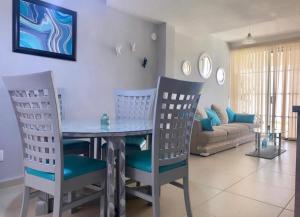 a dining room with a table and chairs and a couch at CASABONITA II, pie alberca, AirAc in Xochitepec