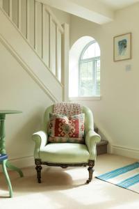 a chair sitting in a room with a window at Cotswold Stable Cottage in Bibury +7 photos