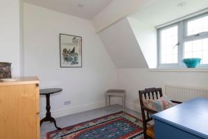 a room with a chair and a table and a window at Cotswold Stable Cottage in Bibury