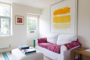 a living room with a couch and a table at Cotswold Stable Cottage in Bibury