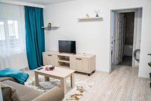 a living room with a tv and a table at TeCa apartament in Rădăuţi