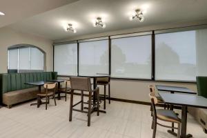 a waiting room with tables and chairs and windows at Drury Inn & Suites Cape Girardeau in Cape Girardeau +46 photos