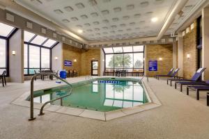 a pool in a building with chairs and tables at Drury Inn & Suites Cape Girardeau in Cape Girardeau