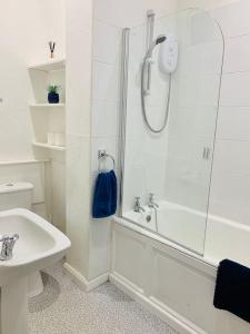 ein weißes Badezimmer mit Dusche und Waschbecken in der Unterkunft Quiet apartment close to station & Stirling Castle in Stirling