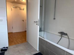 a bathroom with a shower and a tub with a hose at City Wohnung Zwickau in Zwickau