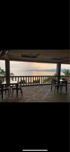 a group of tables and benches sitting on a patio at KJT Travellers Inn in Guindulman