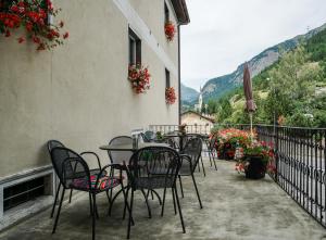 een tafel en stoelen op een balkon met bloemen bij Hotel Adler Garni in Zernez