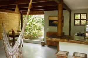 a living room with a hammock in a house at Vila Fruta Pão in Caraíva