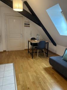 a living room with a table and a couch at L'écume des jours in Colmar