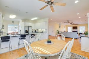 Waterfront Oak Island Home with Dock في أوك آيلاند: مطبخ وغرفة طعام مع طاولة وكراسي خشبية