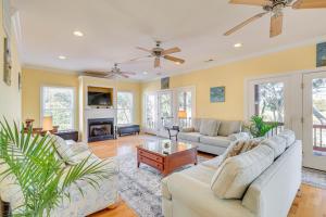 Waterfront Oak Island Home with Dock في أوك آيلاند: غرفة معيشة مع كنبتين ومدفأة