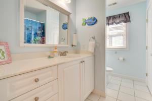Waterfront Oak Island Home with Dock في أوك آيلاند: حمام مزود بحوض ومِرآة +34 صورة