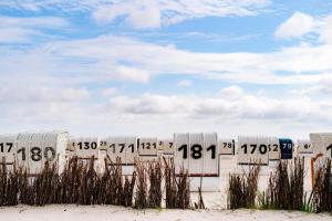 a row of beach chairs in the sand on the beach at Seebreeze 50 2 N in Wangerland