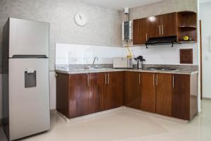 a kitchen with wooden cabinets and a refrigerator at Apartamento Unik Cartagena Edificio Poseidón in Cartagena de Indias +96 photos
