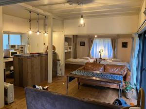 a living room with a couch and a room with a kitchen at 一棟貸宿ほしなや in Nagano