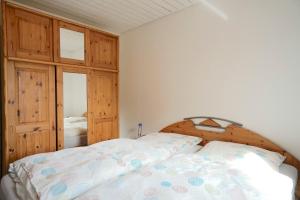 a bedroom with a bed with a wooden headboard at Ferienwohnung Isi-Blick in Osterby