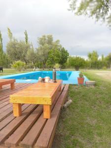 a wooden table sitting on a deck next to a pool at Nostraterra in San Rafael