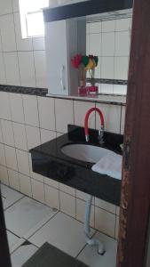 a bathroom with a sink with a red faucet at Casa da ilse in Foz do Iguaçu