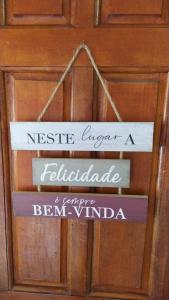 a wooden door with two signs hanging on it at Casa da ilse in Foz do Iguaçu