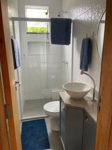 a bathroom with a shower and a toilet and a sink at Floripa Jurerê, pé na areia! Apto 6 in Florianópolis