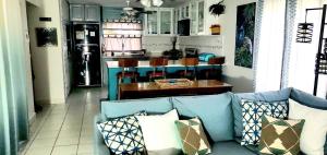 a living room with a blue couch and a kitchen at Amaryl The Dream St Lawrence Gap 2BR condo with pool in Christ Church