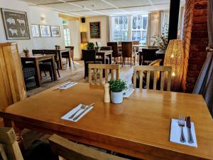 a dining room with a wooden table and chairs at The Ship Inn in Dymchurch