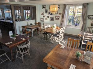 a dining room with wooden tables and chairs at The Ship Inn in Dymchurch