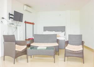 a room with three chairs and a table and a bed at Casas Paraiso in Santa Marta
