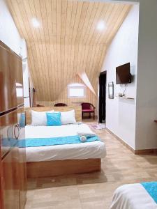 een slaapkamer met een groot bed met een houten plafond bij Khách sạn Trí Đức in Da Lat