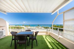 a balcony with a table and chairs and the ocean at My SWEET DIVA NUI in Faaa