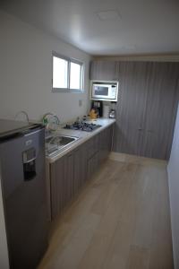 a kitchen with wooden cabinets and a stove top oven at Habitación CI Vintage En Coyoacán in Mexico City