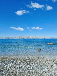 una spiaggia con rocce e acqua blu di Apartments with a parking space Senj - 16747 a Senj Altre 8 foto