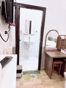 een badkamer met een douche, een wastafel en een bureau bij Khách sạn Trí Đức in Da Lat +24 foto's