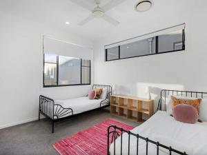 a bedroom with two beds and a chair and a window at Cylinders Coastal Deluxe in Kingscliff +18 photos