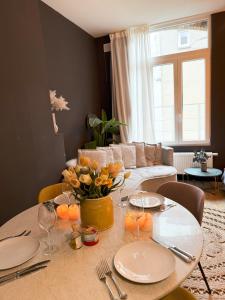 een woonkamer met een tafel met borden en een bank bij Sān home’s in Antwerpen