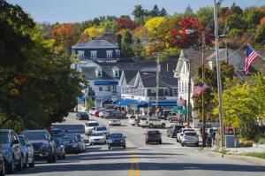 a busy street in a small town with cars parked at Cottage 12 - King Bed Child Loft w Twin Private Bath Kitchenette Pets Allowed Fee applies in Wolfeboro +13 photos
