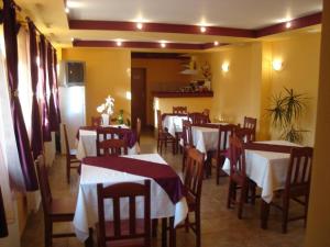 a restaurant with tables and chairs with red and white table cloth at Pensiunea Casa Vulkan in Ocna Sibiului