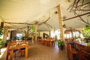 an empty restaurant with wooden tables and chairs at Buona Resort in Panglao