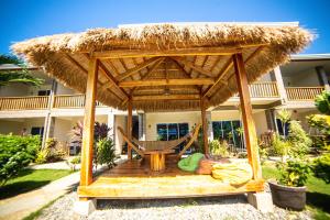a gazebo with a hammock in front of a house at Buona Resort in Panglao