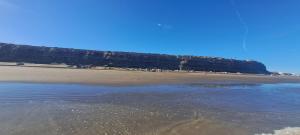 a group of people standing on a beach at Mini casa relajante in Balneario El Condor