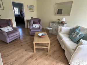 a living room with two chairs and a couch and a table at Daisy Cottage in Lymington +24 photos