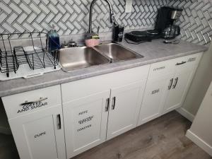 a kitchen with white cabinets and a sink at Winnipeg Radiant Home in Winnipeg