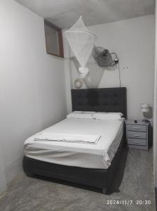 a bedroom with a bed in a room with a lamp at La casa de Joan in Máncora