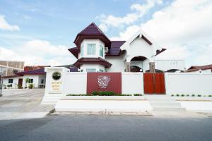 a white house with a red and white fence at The Star Pool Villa Hatyai in Hat Yai