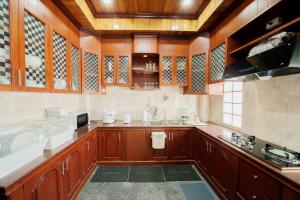 a kitchen with wooden cabinets and a sink at The Star Pool Villa Hatyai in Hat Yai